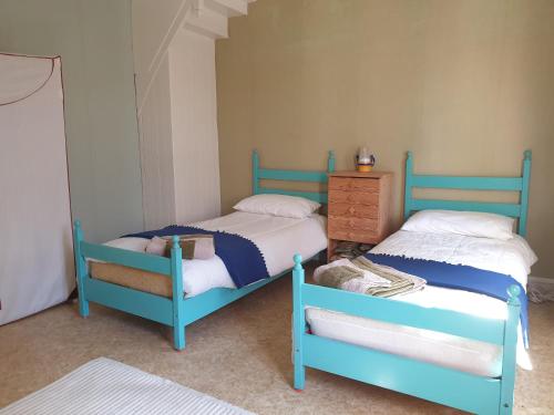two blue beds in a room with a dresser at Saint Cyr du Bailleul - Maison in Saint-Cyr-du-Bailleul