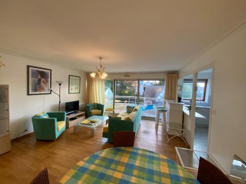 un salon avec un canapé, des chaises et une table dans l'établissement L'Oustal Coeur de ville, à Le Touquet-Paris-Plage