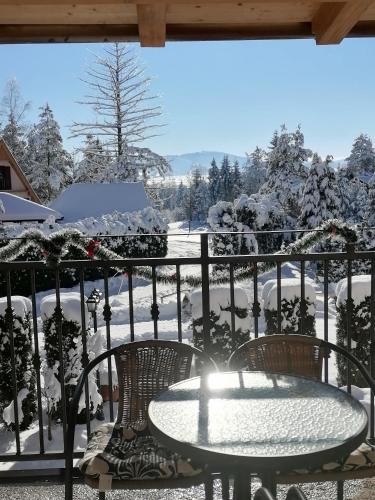 a table and chairs on a balcony in the snow at Villa Bozovic in Zlatibor