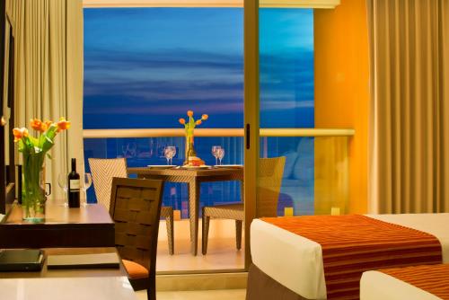 a dining room with a table and a view of the ocean at Sunset Plaza Beach Resort Puerto Vallarta All Inclusive in Puerto Vallarta