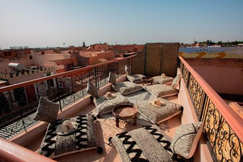 a balcony with chairs and tables on a balcony at Riad Ksar Al Amal & Spa in Marrakech