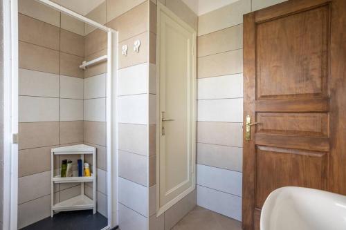 Un baño con ducha y puerta de madera. en Brisas de Jover, en La Laguna