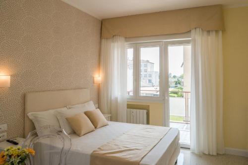 a bedroom with a bed and a large window at Guest House Train Station Venice - Atika & Atif in Mestre