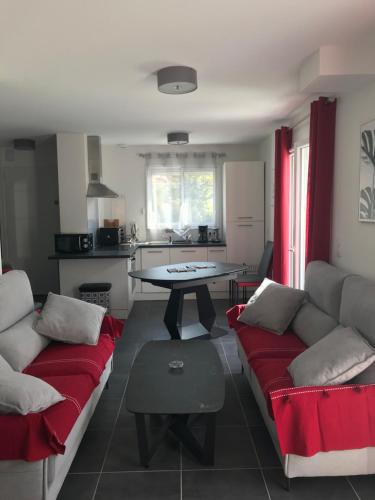 un salon avec un canapé rouge et une table dans l'établissement Maison 8 personnes Biscarrosse bourg, à Biscarrosse