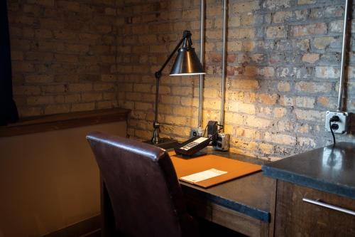 an office with a desk with a telephone and a lamp at The Iron Horse Hotel in Milwaukee