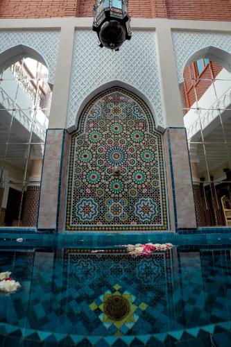 a swimming pool with a mosaic tile wall in a building at Riad Ksar Al Amal & Spa in Marrakech