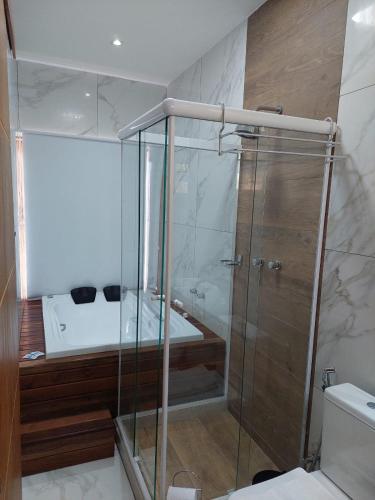a bathroom with a shower and a toilet and a sink at Costa del Mar Hotel Boutique in Miguel Pereira
