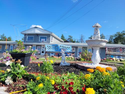 a garden in front of a house with a fountain at Norvic Motel in Coniston
