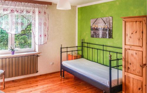 um quarto com uma cama numa parede verde em 3 Bedroom Stunning Home In Darlowo em Darłowo