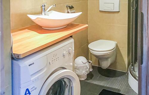 a bathroom with a sink and a washing machine at Amazing Apartment In Bobolin With Wifi And 2 Bedrooms in Bobolin