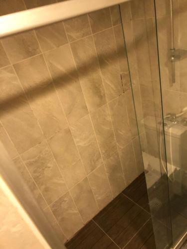 a shower with a glass door next to a toilet at ALASKA - TUYAP PALACE in Kırac