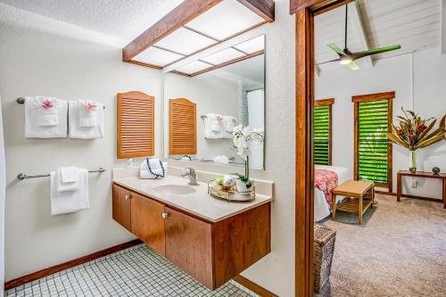 bagno con lavandino e specchio di Waikomo Stream Villas 132 a Koloa