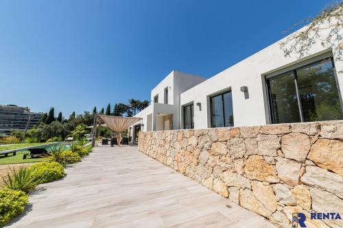 a stone wall next to a house with a walkway at Cannes Hills Lovely Villa Pool & Garden in Le Cannet