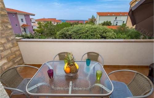 a glass table with a pineapple on it on a balcony at Stunning Apartment In Mandre With Wifi in Mandre