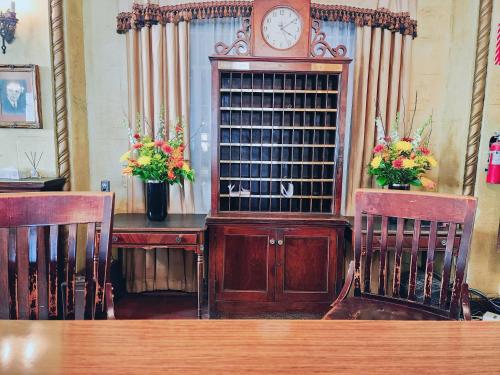 a wooden table with two chairs and a grandfather clock at The Faust Hotel in New Braunfels