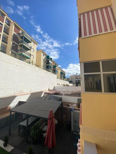 a table and umbrella on a balcony of a building at APARTAMENTO EN LOS CRISTIANOS - FREE WIFI in Los Cristianos