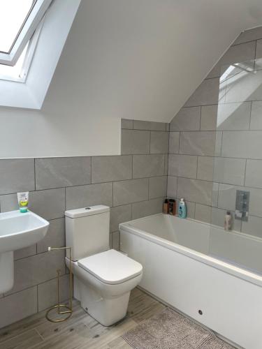 a bathroom with a toilet and a sink and a bath tub at Sea Breeze Cottage Swanage Bay in Swanage