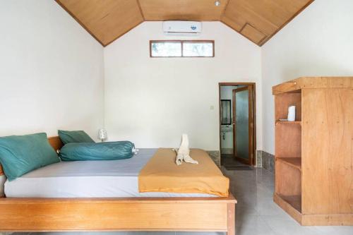 1 dormitorio con 1 cama con almohadas azules y verdes en Run Gilis, en Gili Meno