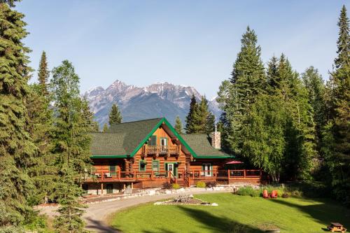 a large log cabin with mountains in the background at Moberly Lodge in Golden