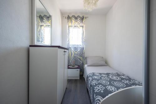 Dormitorio pequeño con cama y espejo en Apartments with a swimming pool Kastel Sucurac, Kastela - 17588, en Kaštela