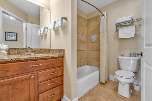 a bathroom with a toilet and a tub and a sink at Bonefish Bay Motel in Marathon