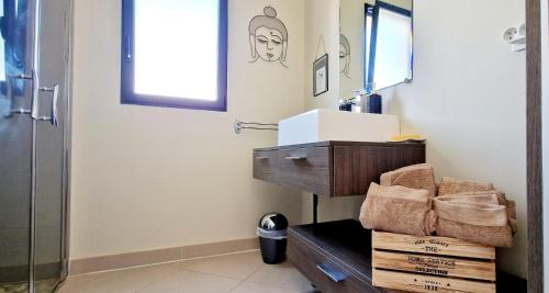 a bathroom with a sink and a mirror at Villa Bistinetti Rez de villa tout confort avec piscine in Penta-di-Casinca