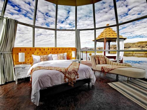 a bedroom with a bed and a large window at Titicaca Lodge Peru in Puno