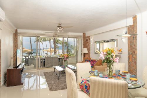 a living room with a table and chairs and a dining room at Ocean Front Condo with Pool Sleeps 6 Adults-Quinta del Mar 203 in Nuevo Vallarta
