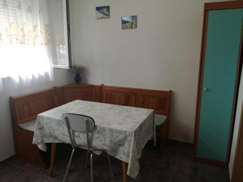 Zimmer mit einem Tisch, 2 Stühlen und einem Fenster in der Unterkunft Apartments by the sea Ladjin Porat, Paklenica - 17624 in Starigrad-Paklenica