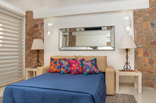 ヌエボ・バジャルタにあるOcean Front Condo with Pool Sleeps 6 Adults-Quinta del Mar 203のベッドルーム(青いベッド1台、鏡付)