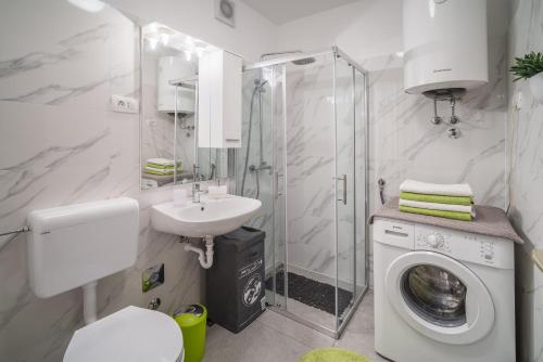 een badkamer met een wasmachine en een wastafel bij Apartments with WiFi Rijeka - 17629 in Rijeka