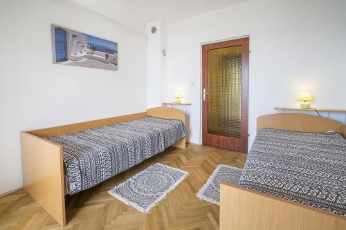 twee bedden in een kamer met houten vloeren bij Apartments with WiFi Rijeka - 17629 in Rijeka