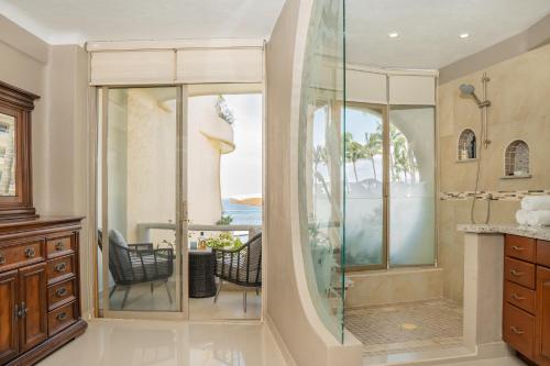 baño con ducha de cristal con mesa y sillas en Ocean Front Condo with Pool Sleeps 6 Adults-Quinta del Mar 203, en Nuevo Vallarta 