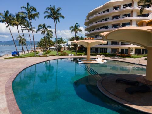 a swimming pool in front of a hotel at Ocean Front Condo with Pool Sleeps 6 Adults-Quinta del Mar 203 in Nuevo Vallarta