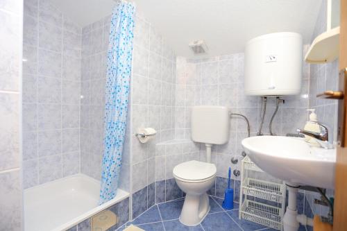 uma casa de banho com um WC e um lavatório em Apartments by the sea Duce, Omis - 17661 em Duće