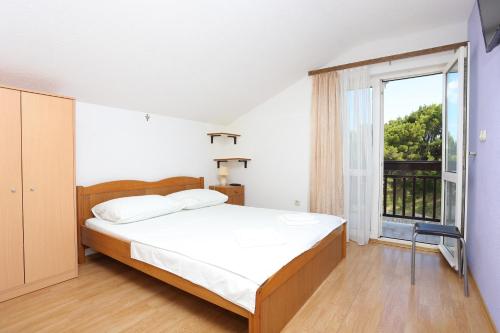 um quarto com uma cama e uma grande janela em Apartments by the sea Duce, Omis - 17661 em Duće