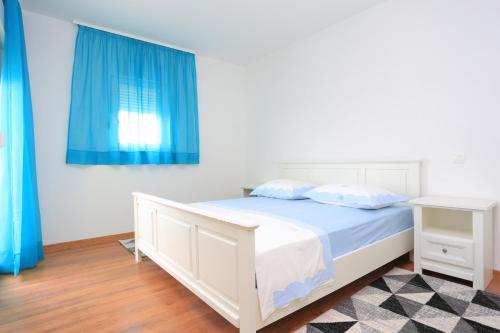 索林的住宿－Apartments with a parking space Solin, Split - 17669，卧室配有白色的床和蓝色窗帘