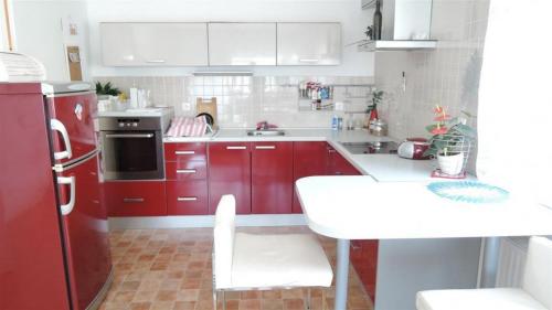 a small kitchen with red cabinets and a white table at Apartments with a parking space Sveta Nedelja, Prigorje - 17613 in Sveta Nedjelja