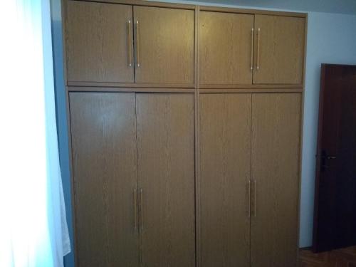 - un placard avec des armoires en bois dans l'établissement Apartment Crikvenica 17675a, à Crikvenica