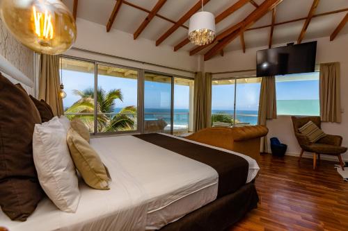 een slaapkamer met een bed en uitzicht op de oceaan bij Hotel Del Mar Mancora in Máncora