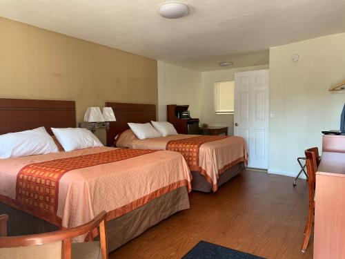 a hotel room with two beds and a television at Redwood Inn in Santa Rosa