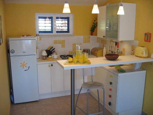 a kitchen with a white refrigerator and a counter at Family friendly apartments with a swimming pool Kaprije - 17692 in Kaprije