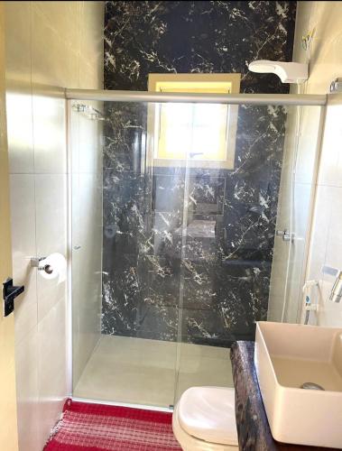 a bathroom with a shower with a toilet and a sink at Casa Ouro no centro de Diamantina in Diamantina