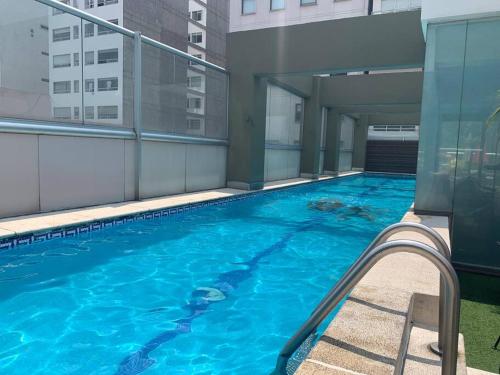 een groot zwembad aan de zijkant van een gebouw bij Hermoso depto c/alberca y gym Polanco in Mexico-Stad