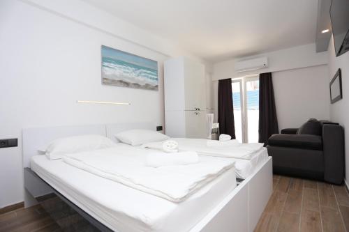 ein weißes Schlafzimmer mit einem großen Bett und einem Sofa in der Unterkunft Rooms with a swimming pool Kastel Stafilic, Kastela - 17710 in Kaštela