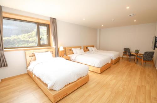 a hotel room with two beds and a window at Daedunsan Hotel in Wanju