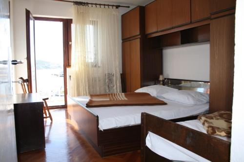 a bedroom with two beds and a table and a window at Apartments by the sea Vinisce, Trogir - 17590 in Vinišće