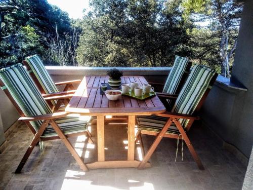 a wooden table and chairs sitting on a balcony at Apartment Silba 17603a in Silba