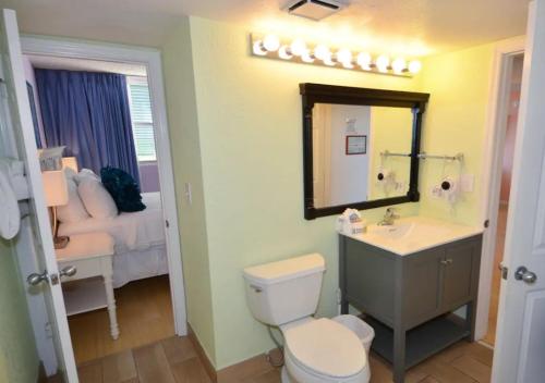ein Badezimmer mit einem WC, einem Waschbecken und einem Spiegel in der Unterkunft Sunrise Suites by TO in Key West