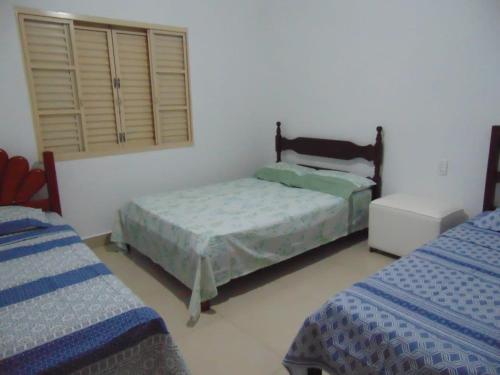 a bedroom with two twin beds and a window at Rancho do Pedro in Capitólio